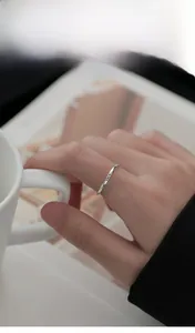 Detailed view of S925 sterling silver ring with Luck engraving worn by a model