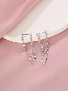 Détail des boucles d'oreilles puces à double chaîne en argent S925 sur fond de soie
