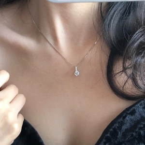 Detail of S925 sterling silver solitaire necklace on model with a black velvet dress