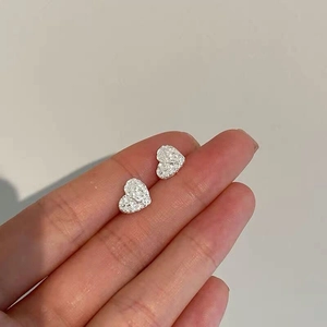 Detailed macro shot of S925 sterling silver heart studs with textured tin foil finish