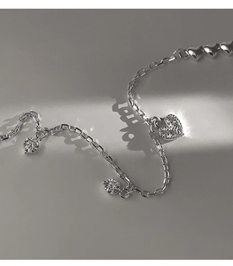 Macro shot of S925 sterling silver heart bracelet with pavé diamonds and round zircon charms