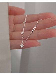 Detail of silver S925 heart bracelet with sparkling pavé stones on a model's wrist