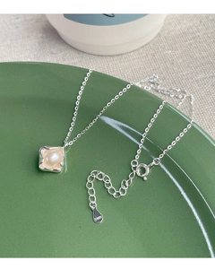 Close-up of S925 sterling silver chain with irregular pearl in a wavy square frame