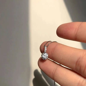 Close-up of S925 sterling silver necklace featuring a four-prong set sparkling single diamond