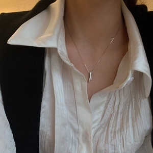 Detailed view of an S925 silver necklace with a sparkling paved geometric column pendant