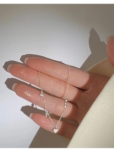Detail of S925 sterling silver heart bracelet with sparkling zircon on a woman's wrist