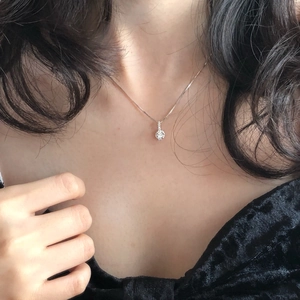 Close-up of S925 sterling silver necklace with sparkling round solitaire diamond pendant