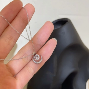 Detailed view of S925 silver star and moon pendant necklace with sparkling cubic zirconia