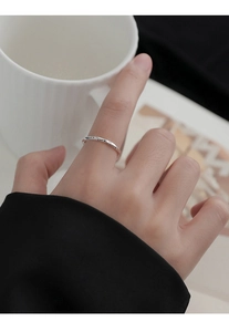 Detailed close-up of S925 sterling silver Mobius ring with luck engraving on the finger