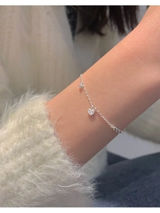 Close-up of S925 sterling silver heart bracelet with pavé diamonds on a person's wrist