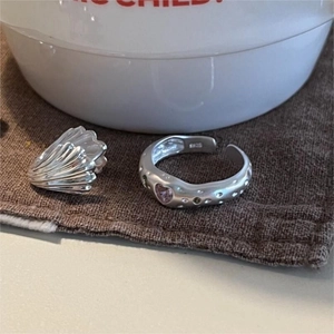 Macro detail of S925 sterling silver ring with irregular pink heart zirconia on linen