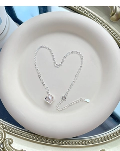 Macro view of S925 silver necklace with irregular pearl pendant on creamy plate