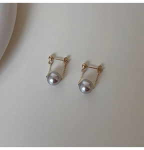 Detail of S925 silver gold earrings featuring double fine chains and gray round pearls