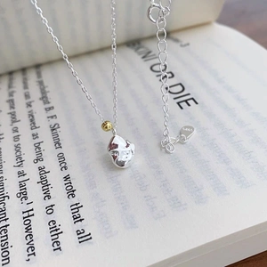 Detail of S925 silver lava pendant necklace with gold bead accent on open book