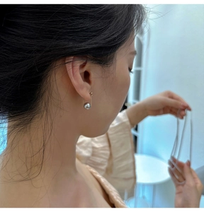 Detail view of 925 sterling silver drop earring with gray round pearl on golden chain