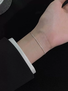 Minimalist S925 sterling silver snake bone chain bracelet worn on wrist over a black blazer