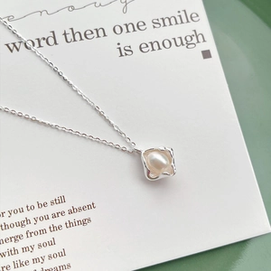 Elegant S925 sterling silver necklace with an irregular pearl pendant on an artistic tray