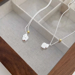 S925 silver irregular meteorite necklace with gold beads on a wooden jewelry box