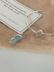 Macro shot of S925 sterling silver oval aquamarine stud earrings with hammered metal texture