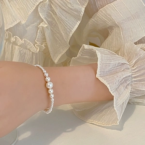 Close-up of elegant gradient pearl bracelet on wrist with soft shimmering finish