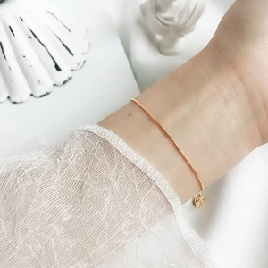 Close-up of minimalist gold S925 sterling silver snake chain bracelet with star charm