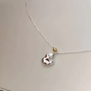 Macro view of S925 sterling silver meteorite necklace with gold bead detail on white