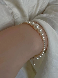 Detail of S925 silver bracelet with gradient white pearls and gold extension chain