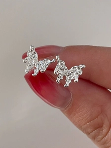 Detail view of S925 silver butterfly stud earrings with molten lava texture on fingertips