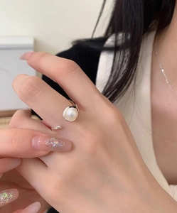 Close-up of elegant S925 sterling silver ring featuring a soft white freshwater pearl on finger