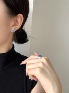 Close-up of S925 silver stud earrings and matching ring with blue aquamarine stones