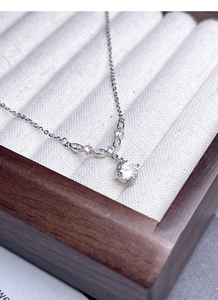 Dettaglio collana in argento S925 con pendente a V di diamanti su espositore gioielli
