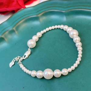 Close-up of S925 sterling silver pearl bracelet with lobster clasp and heart charm