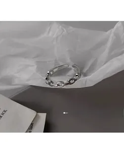 Close-up of S925 sterling silver chain link open ring on minimalist textured paper