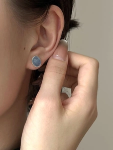 Close-up of S925 sterling silver stud earring with an oval blue aquamarine gemstone