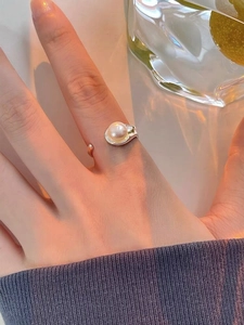 Detailed view of an S925 sterling silver ring with a white freshwater pearl on finger
