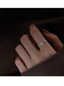 Detail of minimalist S925 sterling silver chain link ring on finger with dark lighting