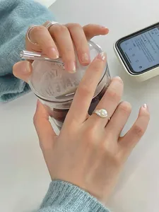 Detail view of S925 sterling silver rings with freshwater pearl worn on model's hand