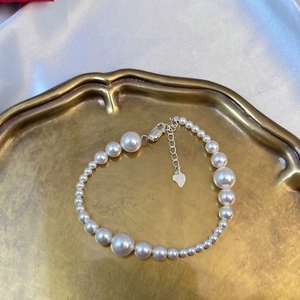 Elegant S925 sterling silver pearl bracelet with gradient beads on a luxury silk background