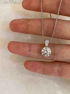 Macro shot of S925 sterling silver necklace with a four-claw set sparkling solitaire diamond