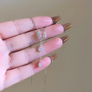Détail d'un collier en argent 925 avec pendentif cœur ajouré et zircons en forme de goutte
