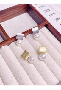 Détail de boucles d'oreilles S925 en or et argent avec métal brossé et perles