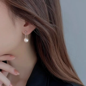 Elegant S925 sterling silver pearl drop earrings worn by model on a blue background