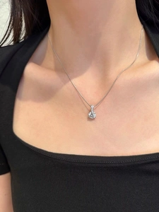 Macro shot of a classic S925 sterling silver solitaire pendant on a woman's neck