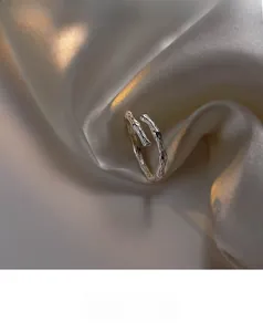 Detailed close-up of S925 sterling silver bamboo joint ring on champagne silk fabric