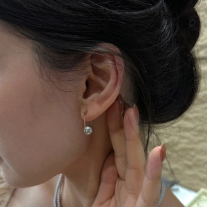 Elegant S925 silver stud earrings with grey pearls and gold chains on a female model