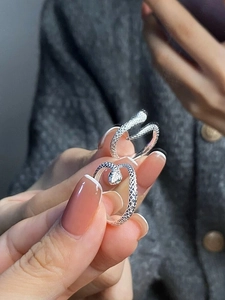 Macro detail of silver snake ring showing intricate scale texture on the band