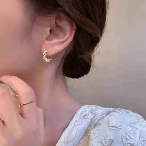Elegant S925 silver pearl stud earrings and gold wave ring worn by a model