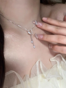 Détail d'un collier en argent 925 avec pendentif cœur papillon et pampilles gouttes