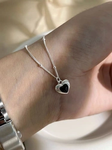 Detailed macro shot of S925 silver heart necklace featuring a sleek black agate stone inlay