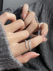 Detailed view of silver snake ring with textured scales and adjustable open design